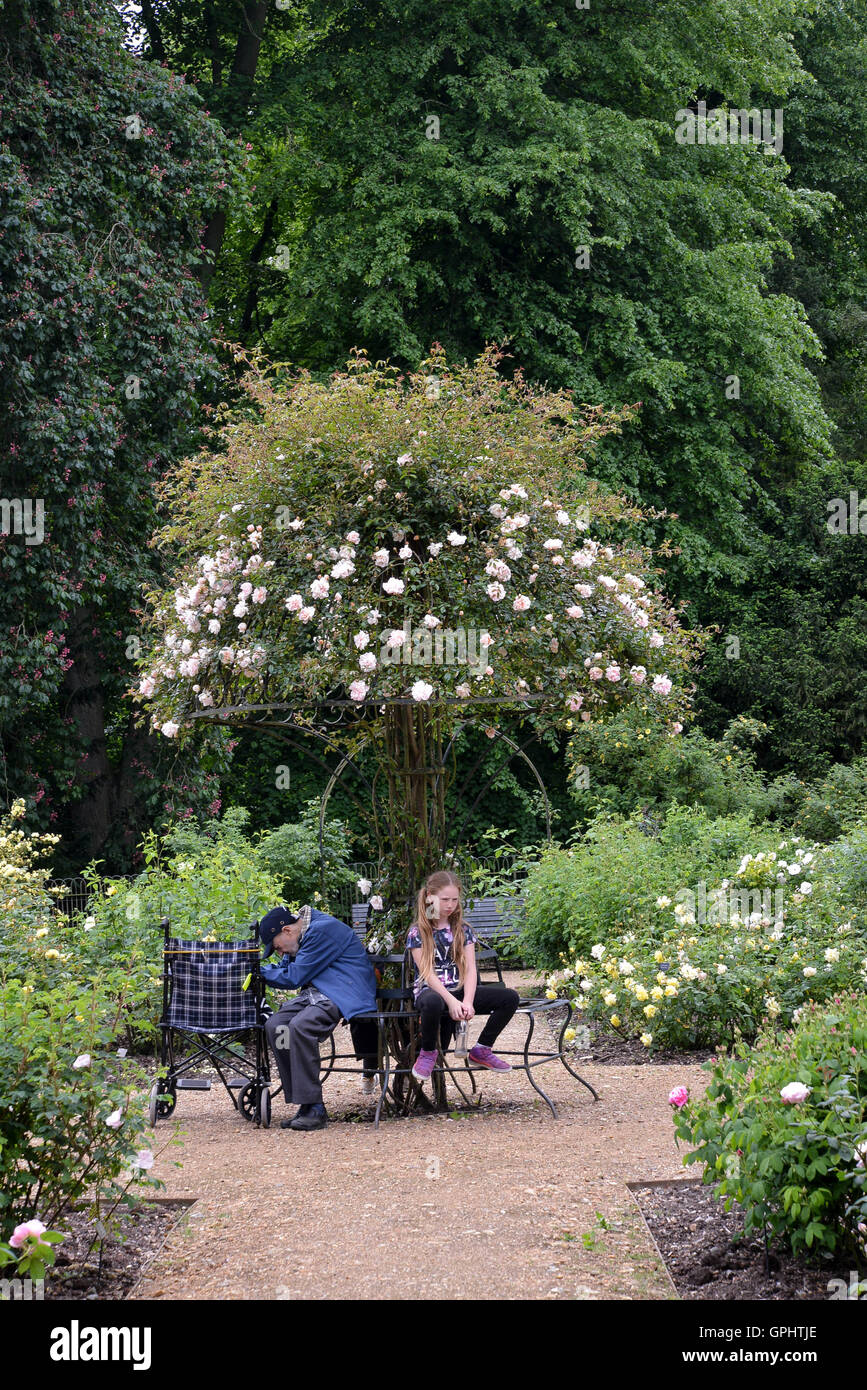 Due generazioni diverse in corrispondenza di estremità opposte della durata della vita umana rappresentata nella natura del giardino Foto Stock