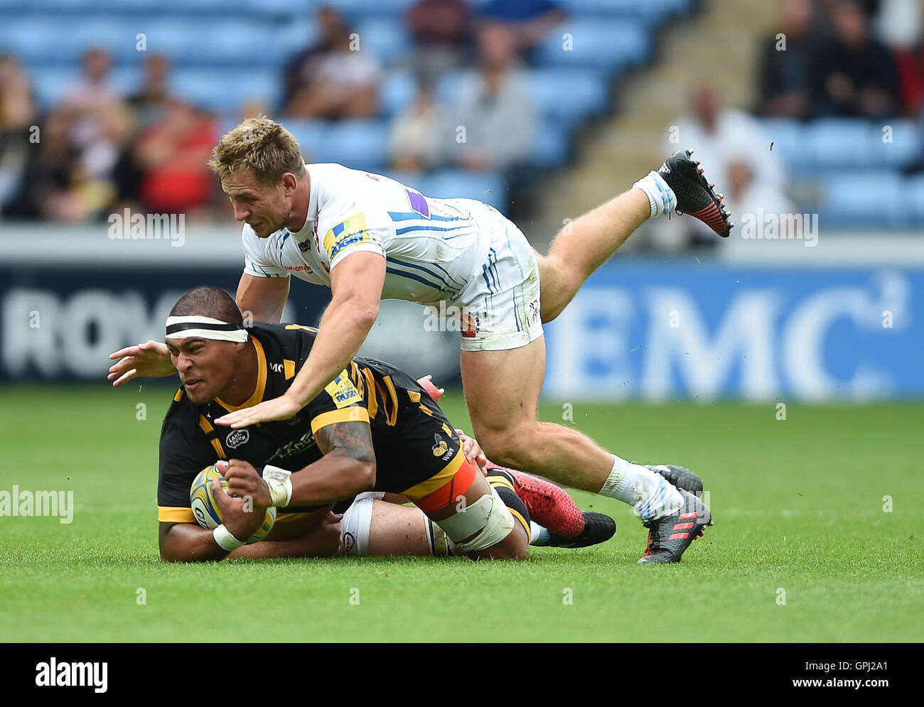 Vespe' Nathan Hughes è affrontato da Exeter Chiefs' Giuliano Salvi (sinistra) e Sam Hill durante la Aviva Premiership corrispondono al Ricoh Arena Coventry. Foto Stock