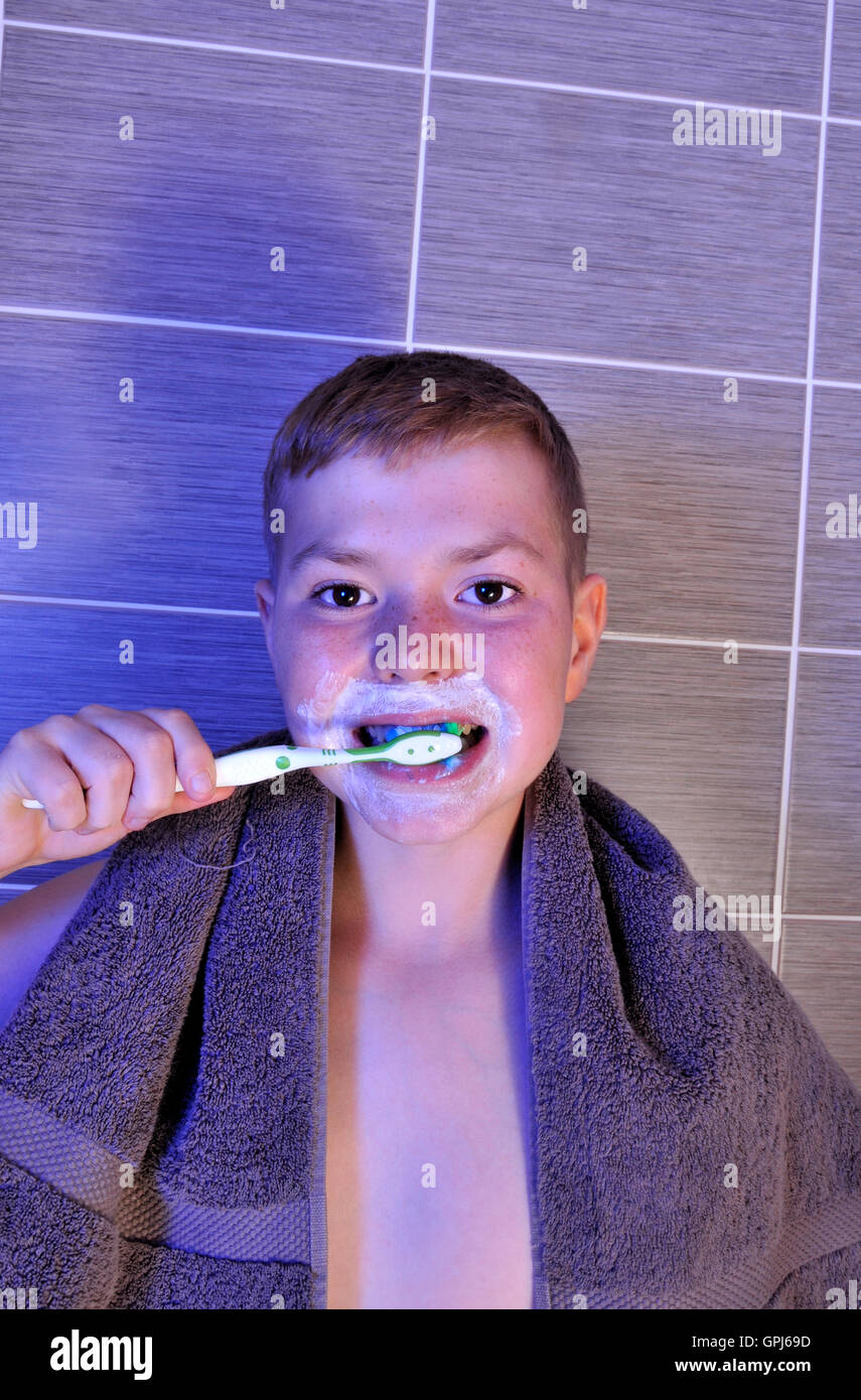 Ragazzo giovane spazzolatura dei denti Foto Stock