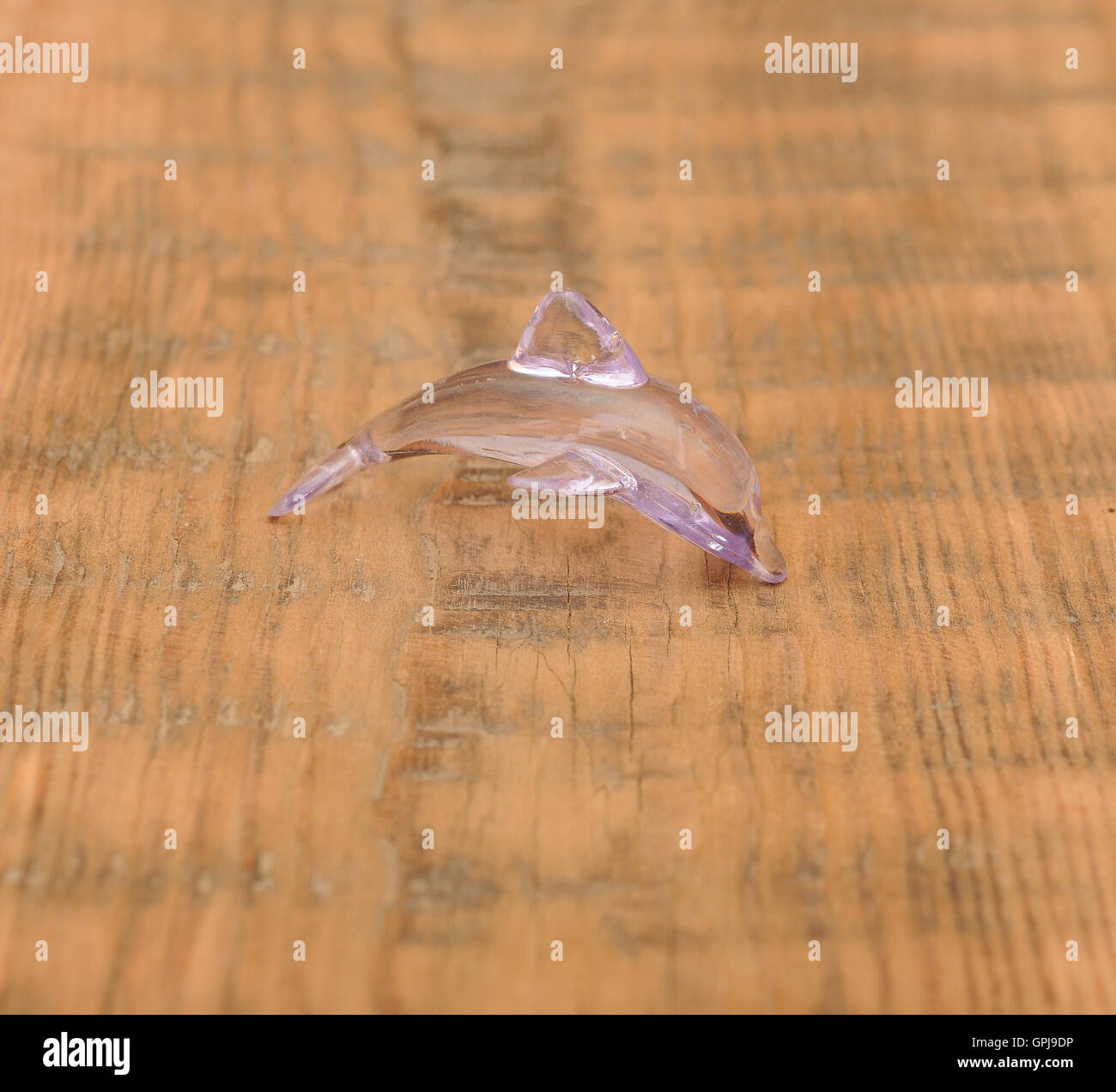 Closeup giocattolo Delfino in vetro su sfondo di legno Foto Stock