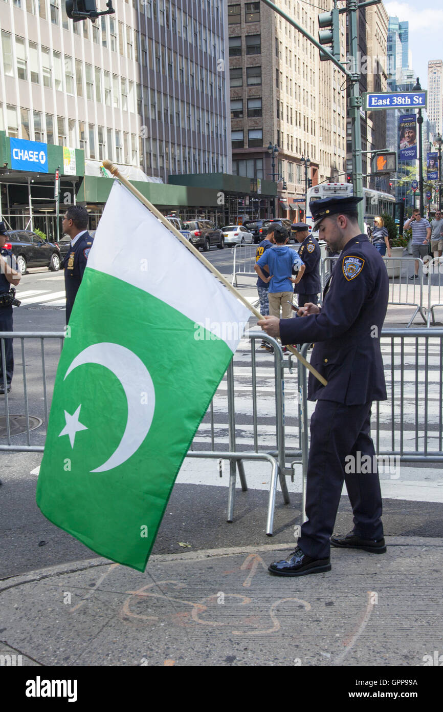 Pakinstani NYPD funzionario di polizia detiene una bandiera pakistana pronto a marzo in Il pakistan Independence Day Parade su Madison Avenue a New York City. Foto Stock