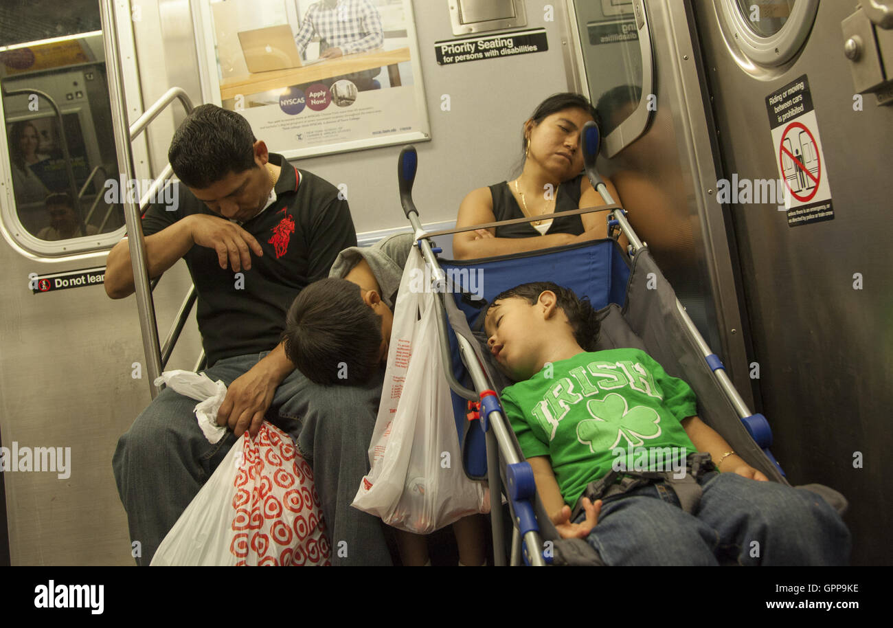 Tutta la famiglia prende un pisolino su una metropolitana di New York in treno in Brooklyn, New York. Foto Stock