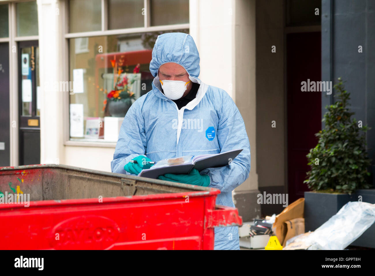 Una delle scene del crimine officer / crimini ufficiali che lavorano e la raccolta delle prove sulla scena di una rapina / furto. Regno Unito. Foto Stock