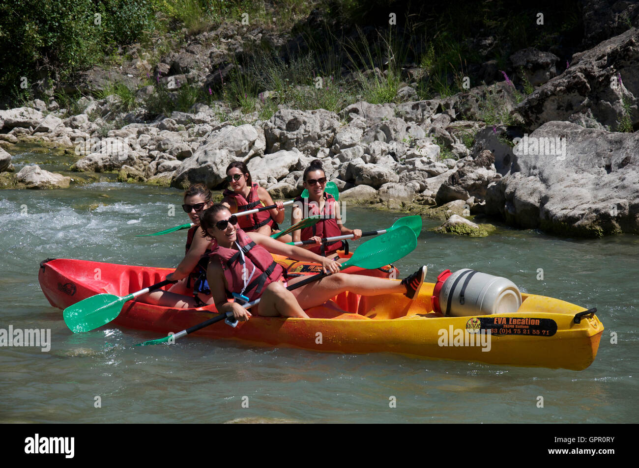 Turismo, acqua-sport. Quattro ragazze adolescenti divertendosi, Messing About in canoa sul veloce che scorre le acque del fiume Drôme. Vacanze estive in Francia. Foto Stock