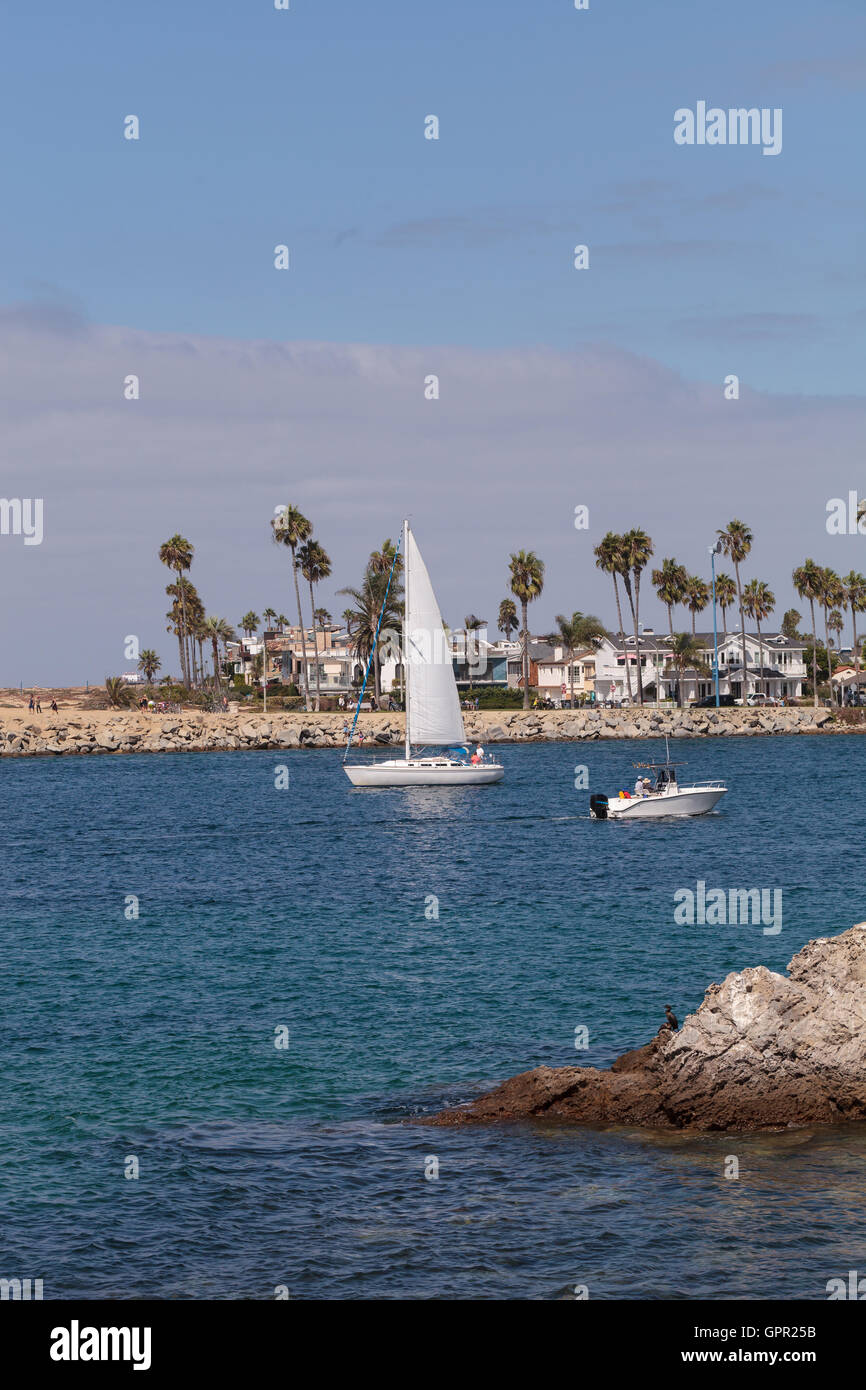 In barca a vela e un motoscafo di lasciare il porto in Corona del Mar, California in estate Foto Stock