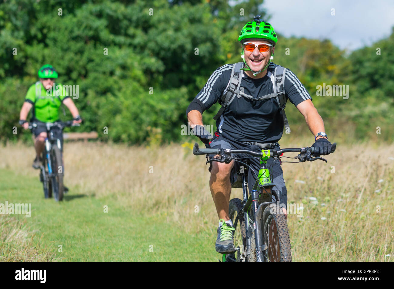 I ciclisti indossare i caschi in campagna godendo la corsa sulla South Downs nel West Sussex, in Inghilterra, Regno Unito. Uno stile di vita sano. Foto Stock