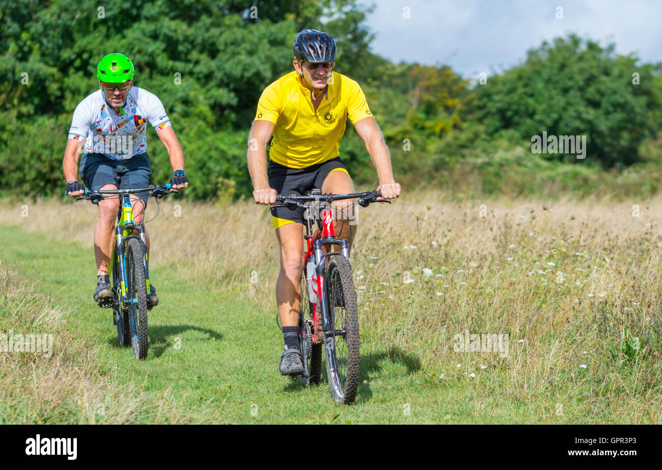 I ciclisti che indossa caschi nella campagna della South Downs nel West Sussex, in Inghilterra, Regno Unito. Uno stile di vita sano. Foto Stock