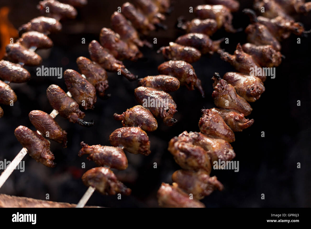 Churrasco, tradizionale barbecue brasiliano, cuori di pollo spiedini cucinati alla griglia. Foto Stock