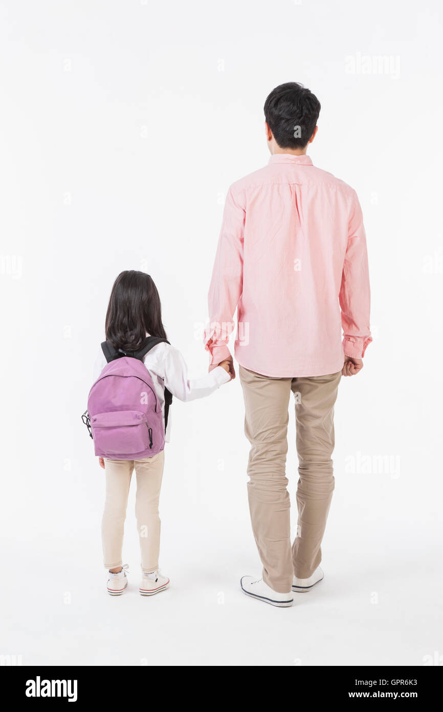 Retro del padre e figlia con borsa scuola mano nella mano Foto Stock