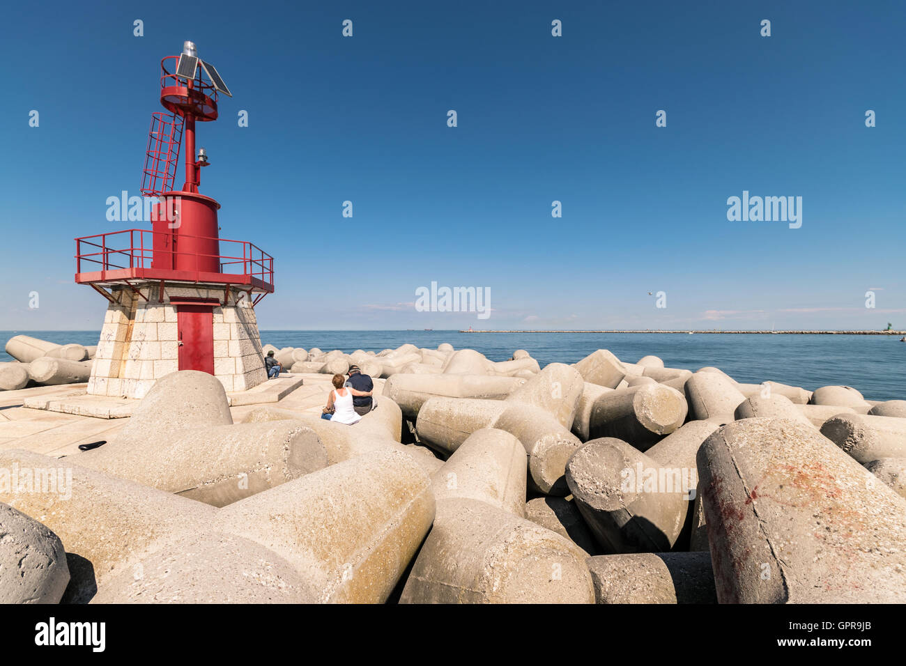 Faro rosso che indica l'entrata del porto. Foto Stock