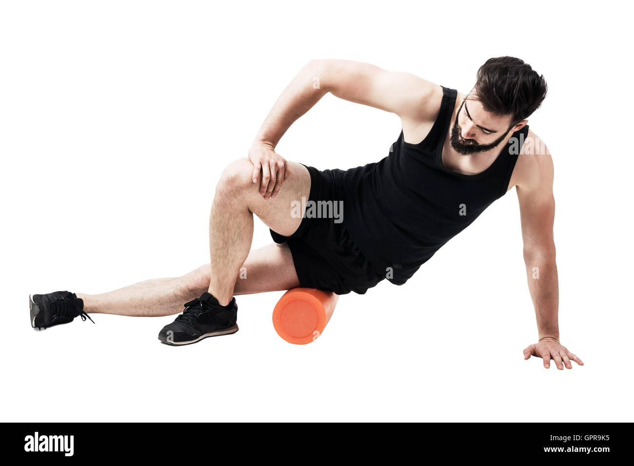 Atleta di massaggio e stretching fascia iliotibial muscolo con rullo in gomma spugna. Corpo pieno lunghezza ritratto isolato su bianco Foto Stock