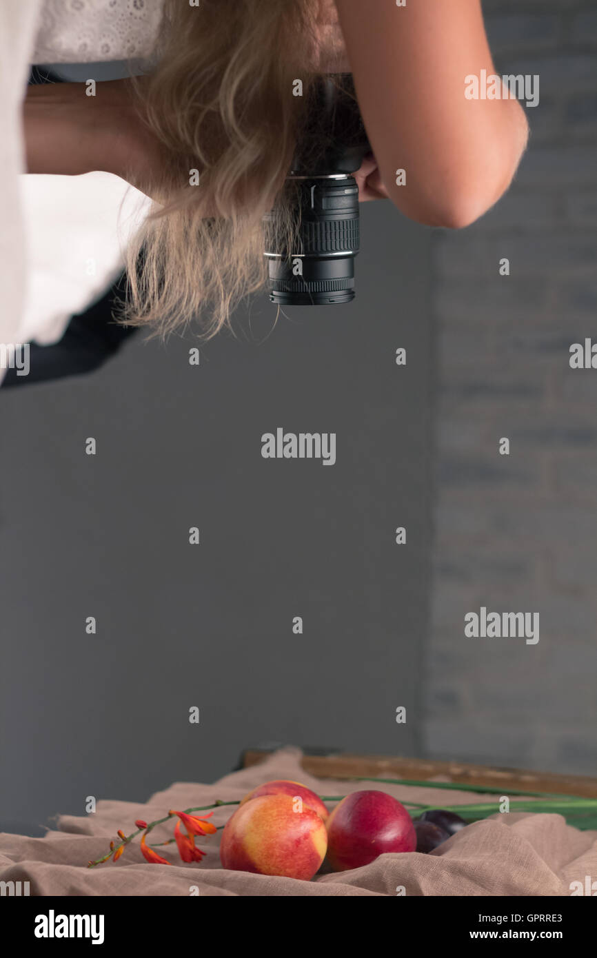 Fotografo ragazza (telecamera ragazza) al lavoro le riprese ancora vita Foto Stock