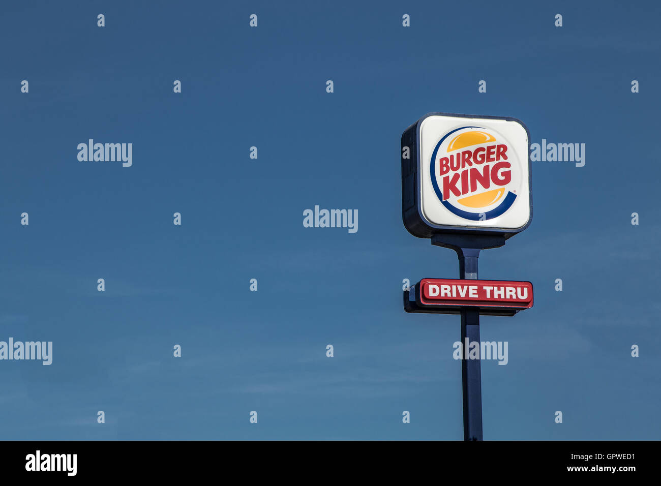 Un segno per un Burger King guidare attraverso il magazzino elevato su un palo alto. Foto Stock