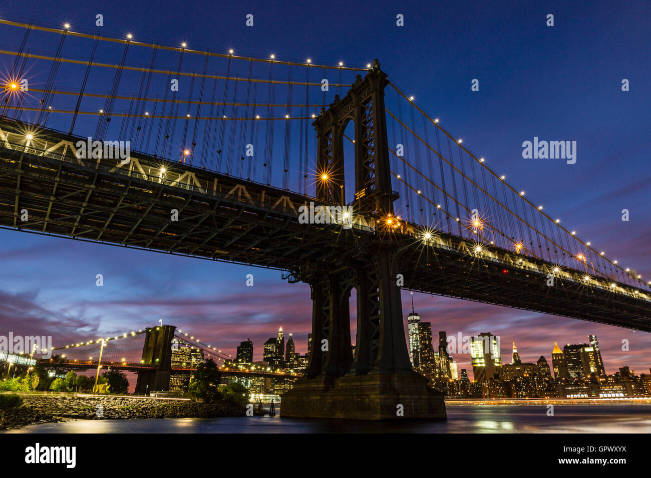 Un colorato twilight vista di Manhattan e Brooklyn Bridge e dello skyline di Manhattan vedi da John Street Park, Brookyn, NY Foto Stock
