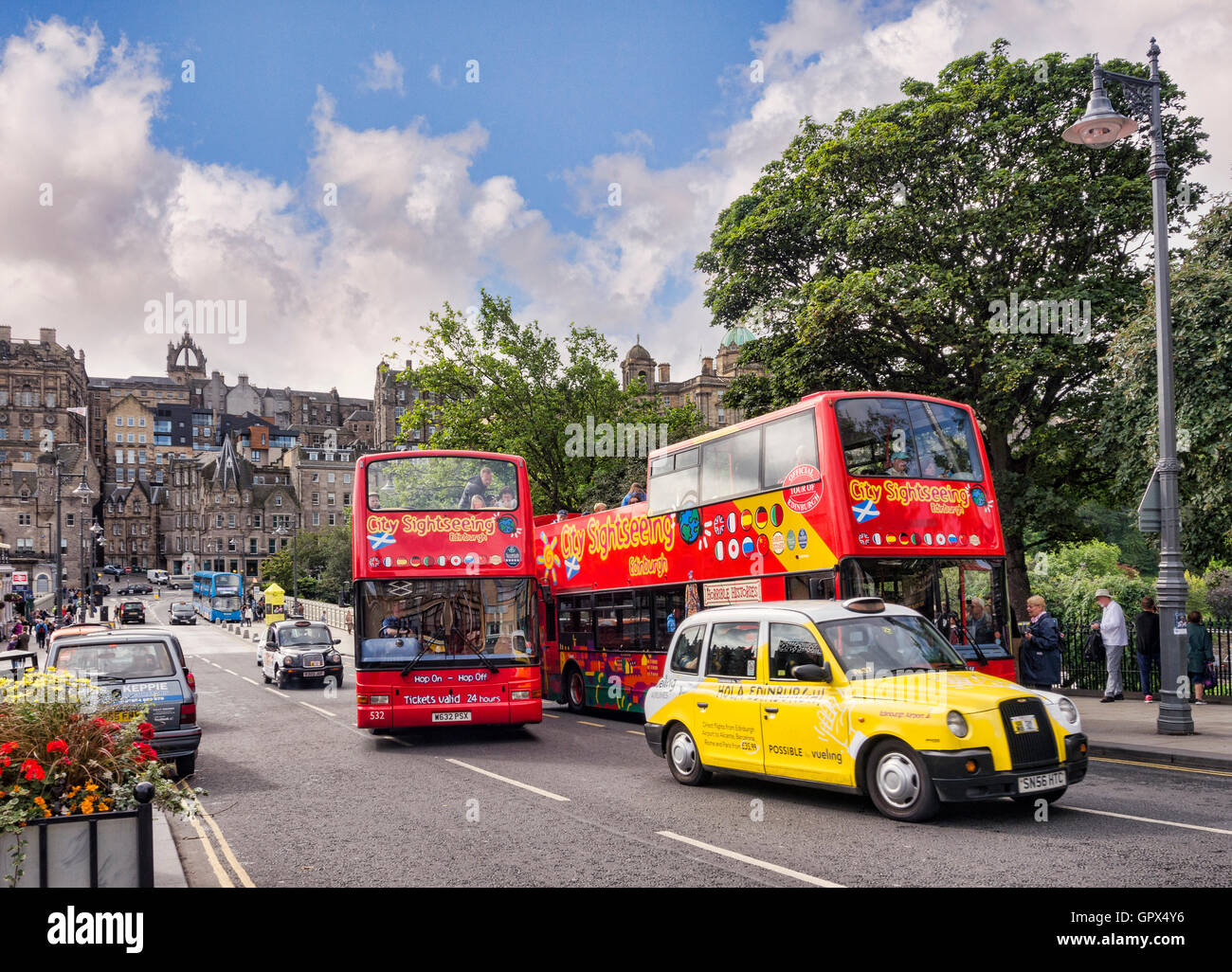 Gli autobus per gite turistiche e un taxi giallo su Waverley Bridge, Edimburgo, con vista sulla Città Vecchia, Edimburgo, Scozia, Regno Unito Foto Stock