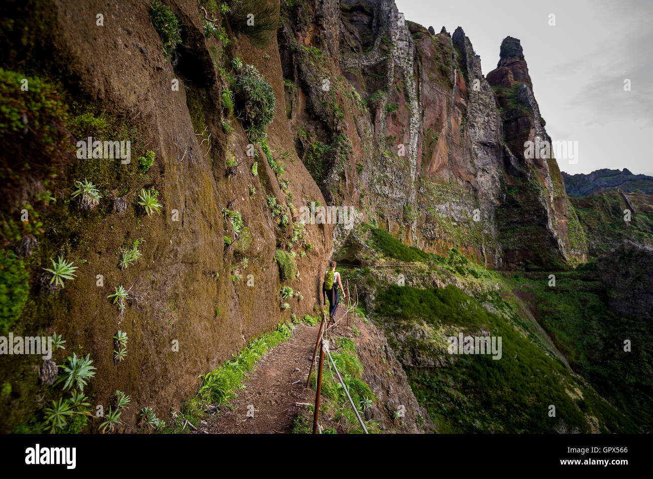 Donna escursionista sta andando sul bordo della ripida montagna Foto Stock