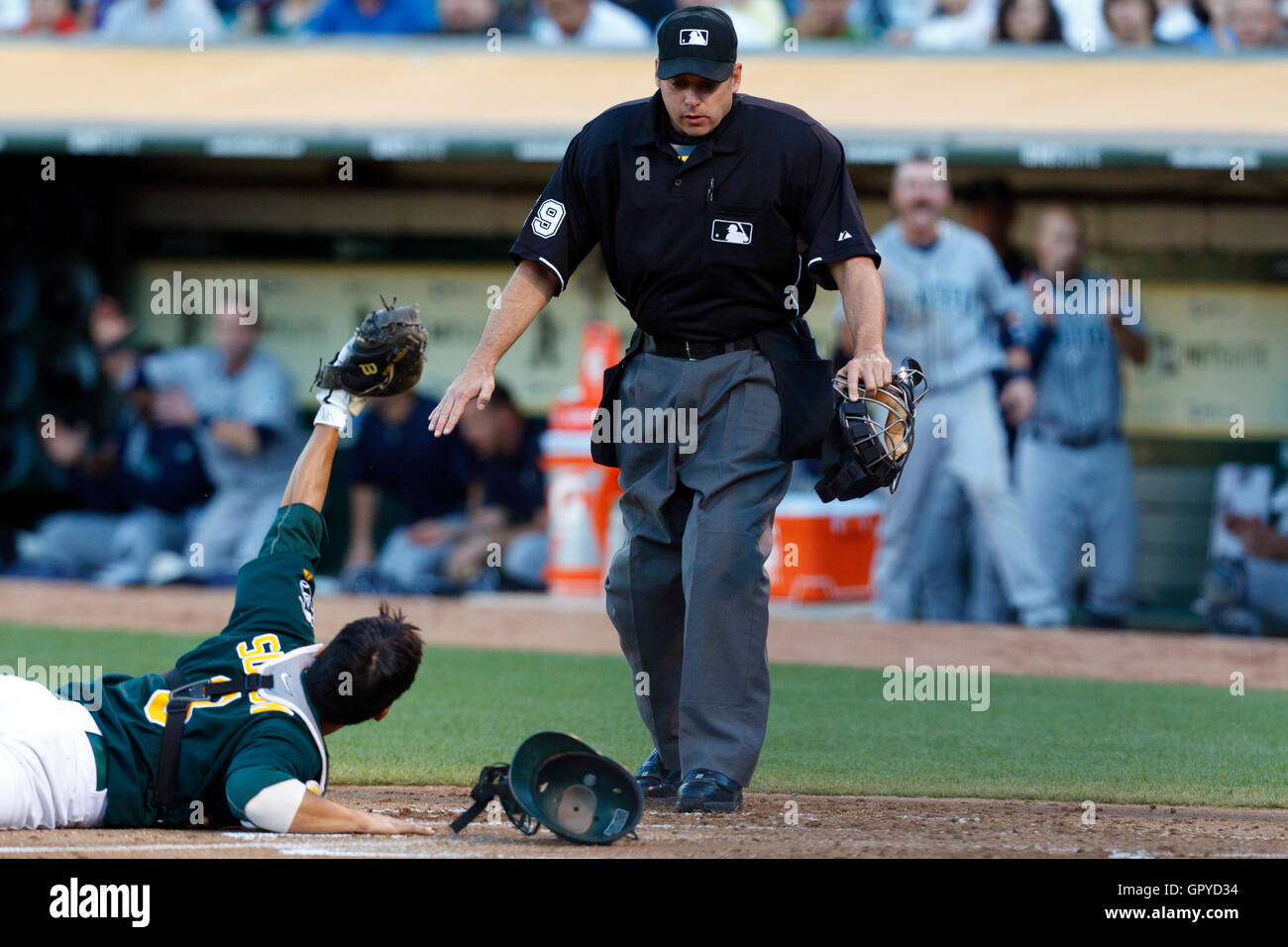 Luglio 5, 2011; Oakland, CA, Stati Uniti d'America; Oakland Athletics catcher Kurt Suzuki (8) Ricorsi alla MLB arbitro Andy Fletcher (49) Dopo manca un tag su Seattle Mariners secondo baseman Dustin Ackley (non mostrato) a casa della piastra durante il secondo inning a O.co Colosseo Foto Stock