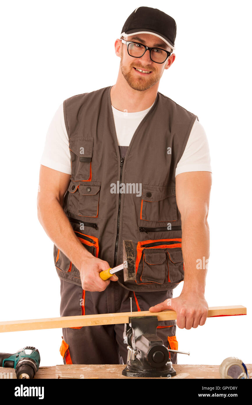 Tuttofare in abbigliamento da lavoro martellamento chiodo con un martello in officina di casa isolata su bianco. Foto Stock