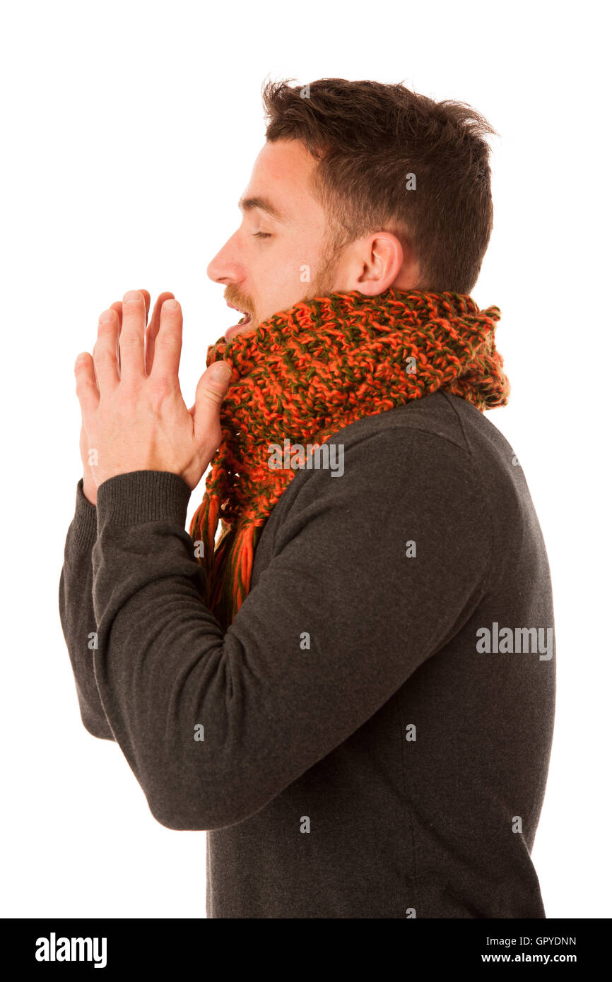 Uomo con influenza e febbre avvolto in una sciarpa holding tazza di tè di guarigione e tosse isolato su bianco. Foto Stock