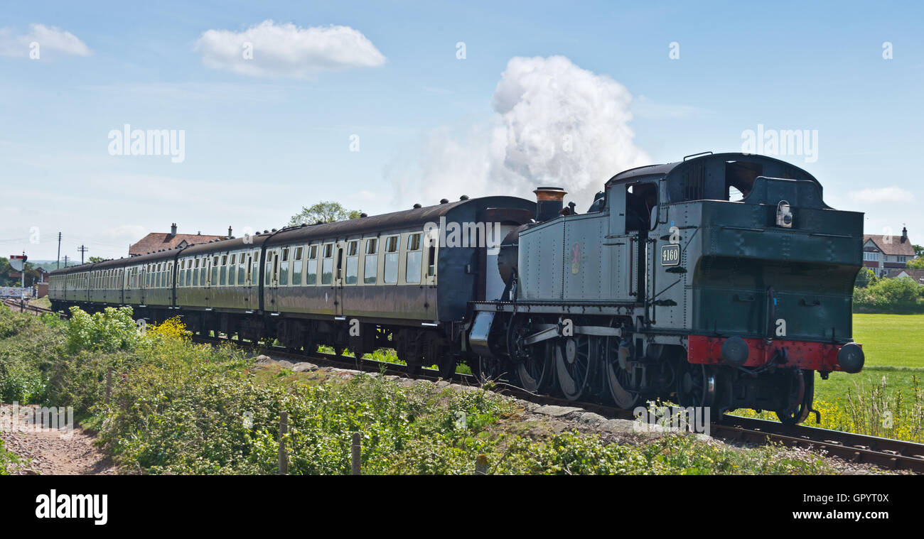 Motore a vapore 4160 tirando un treno lontano dal blu Stazione di ancoraggio sulla West Somerset Railway vicino a Dunster in Somerset Foto Stock