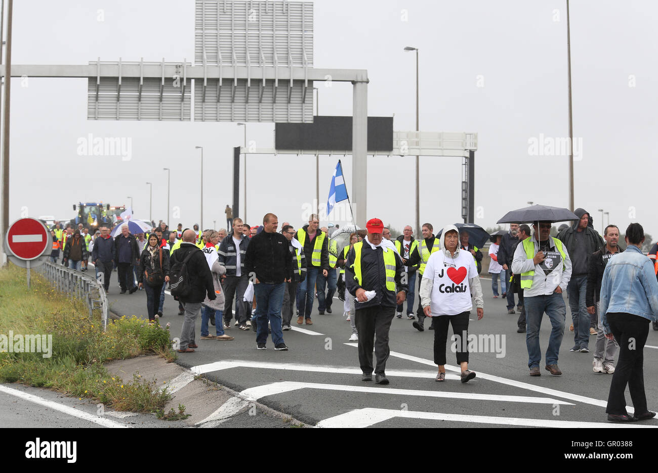 I residenti locali e portuali marzo sull'autostrada A16 a sostegno di un blocco intorno al porto di Calais in Francia come parte di una campagna per la giungla campo migrante per essere demolita. Foto Stock