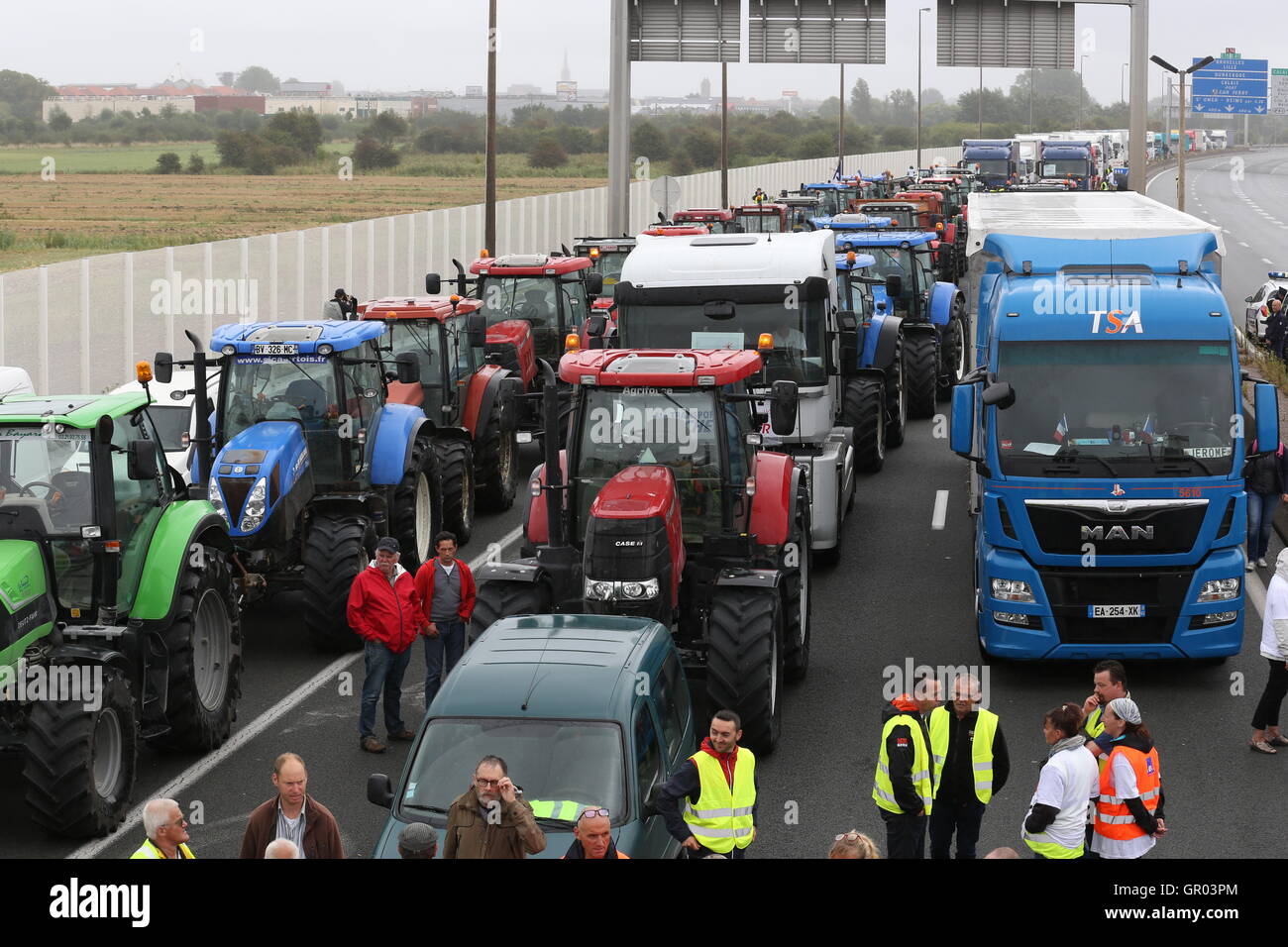I trattori e i camion del blocco, l autostrada A16 nei pressi del porto di Calais in Francia come parte di una campagna per la giungla campo migrante per essere demolita. Foto Stock