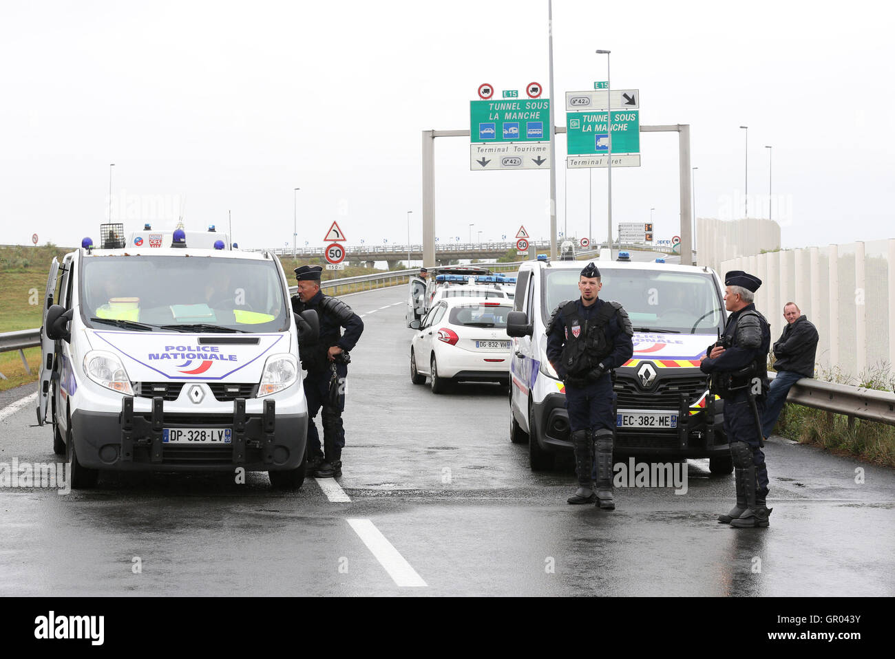Gli ufficiali di polizia di monitorare la situazione durante un blocco per le strade intorno al porto di Calais in Francia come parte di una campagna per la giungla campo migrante per essere demolita. Foto Stock