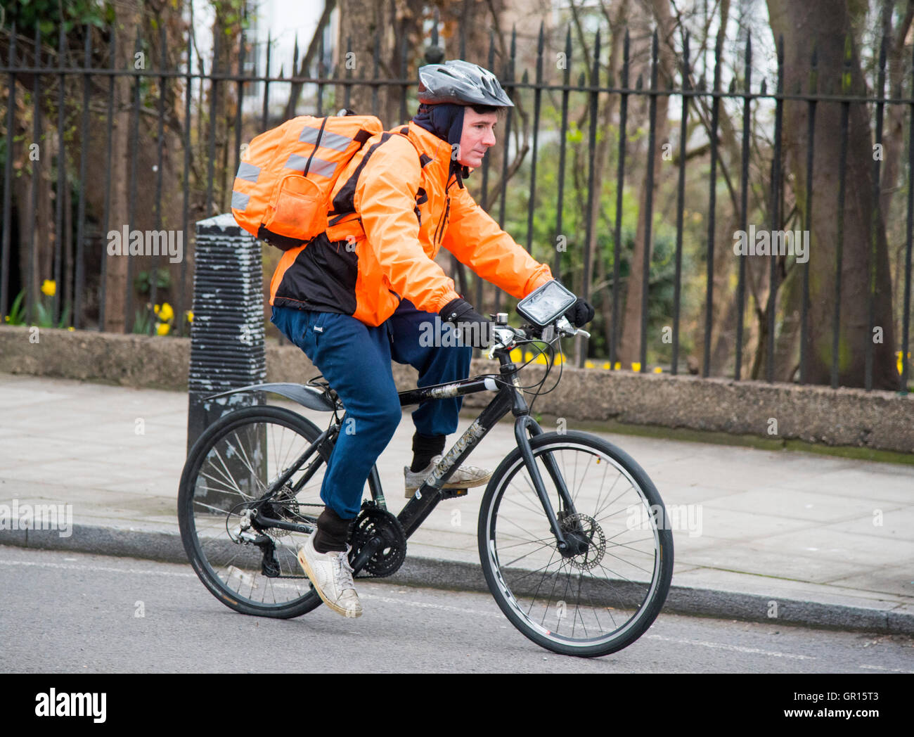 Ciclista in arancione dayglo hi-vis zaino giacca Foto Stock