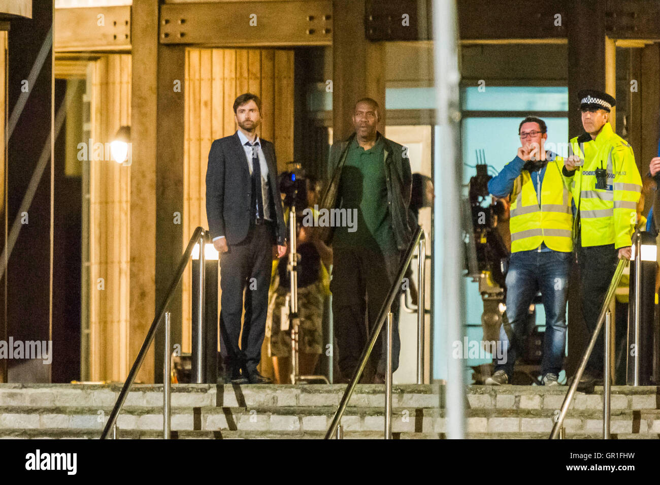 West Bay, Dorset, Regno Unito - 6 Settembre 2016 - David Tennant e Sir Henry Lenny filmare scene di arresto sui gradini della stazione di polizia di notte per la serie 3 di ITV serie hit Broadchurch. Ed Burnett, il personaggio interpretato da Sir Henry Lenny è visto per essere presi in custodia in manette da di Alec Hardy svolto da David Tennant, dopo aver aggredito uno dei mostra caratteri Jim Atwood. Immagine: Graham Hunt/Alamy Live News Foto Stock