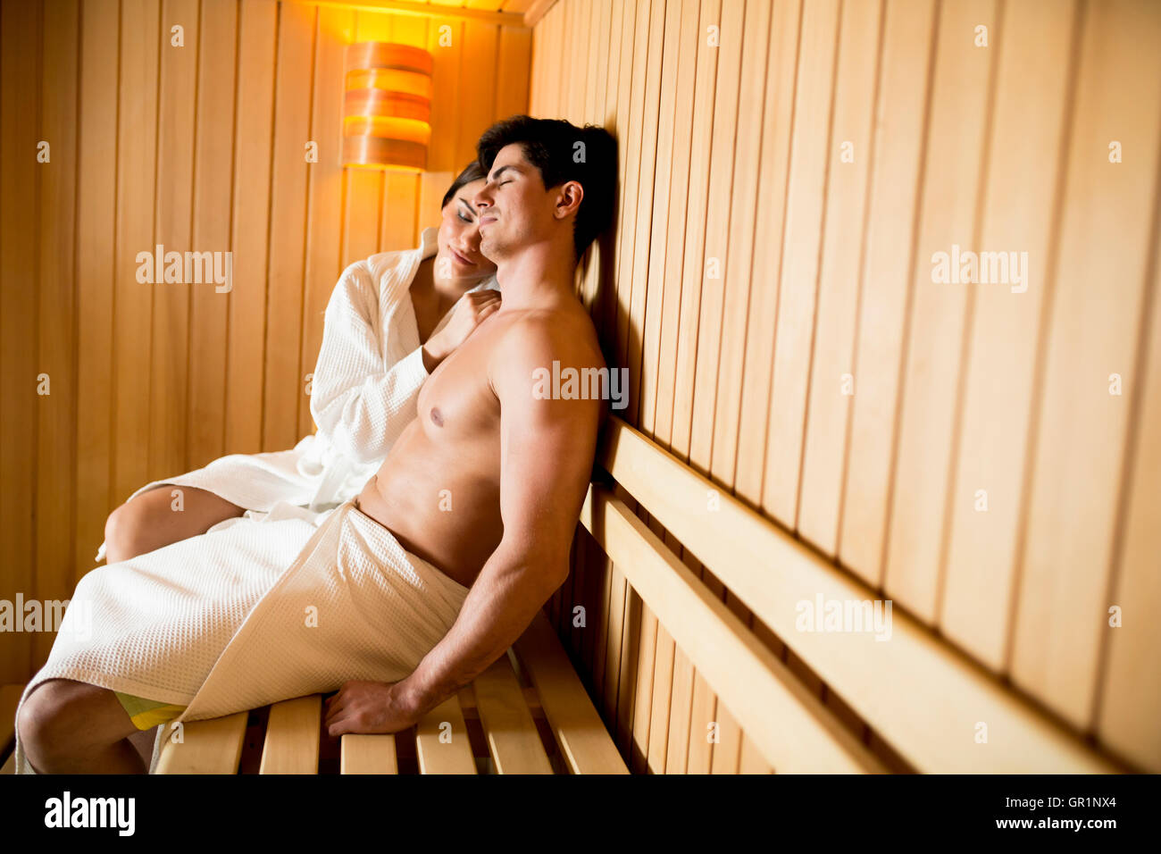 Coppia giovane ralxing nella sauna Foto Stock