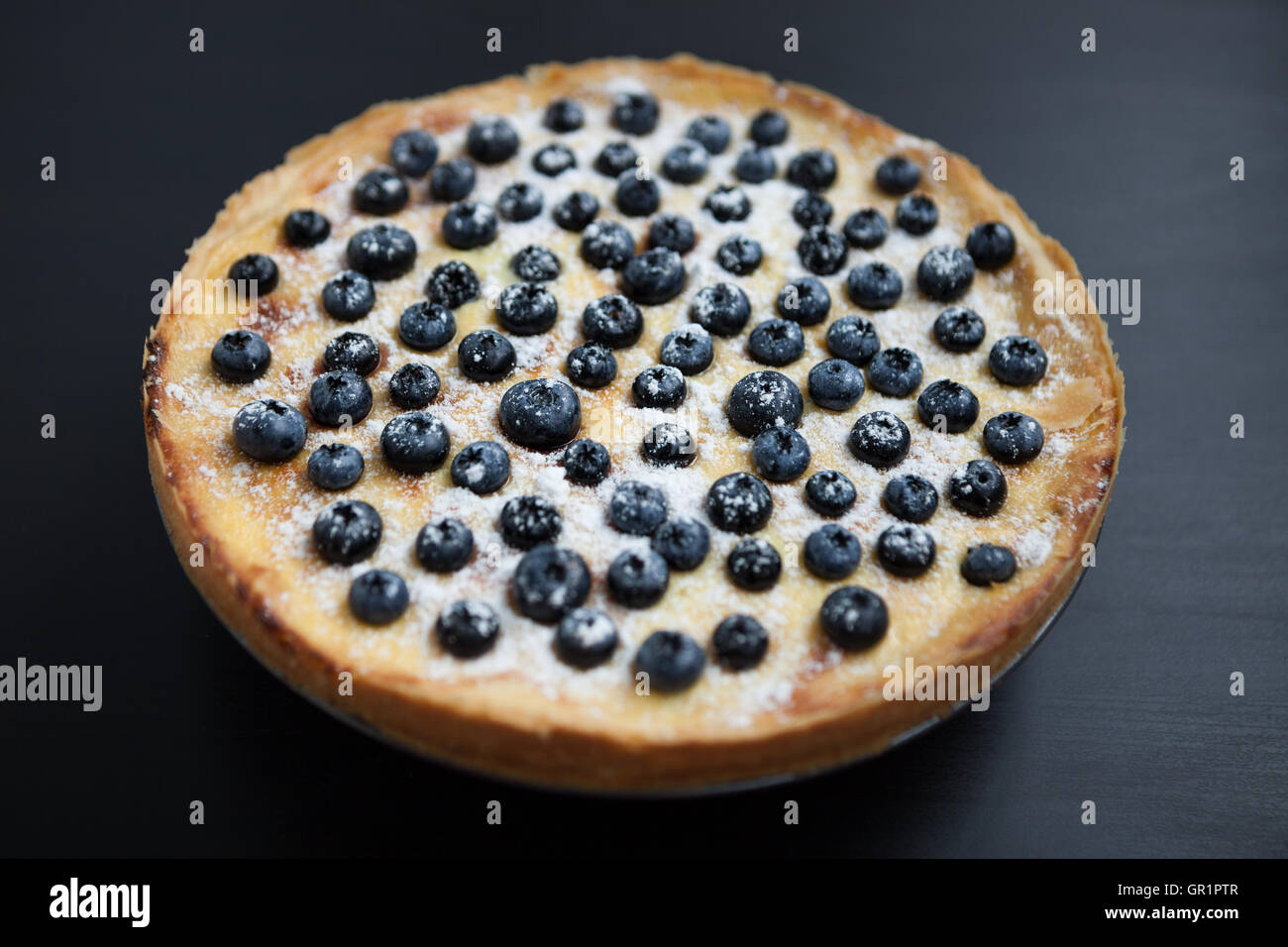 In casa torta bluebrry su una superficie di legno. Fresca pasta cotta su una piastra. Close up macro, squisita crostata cremosa Foto Stock