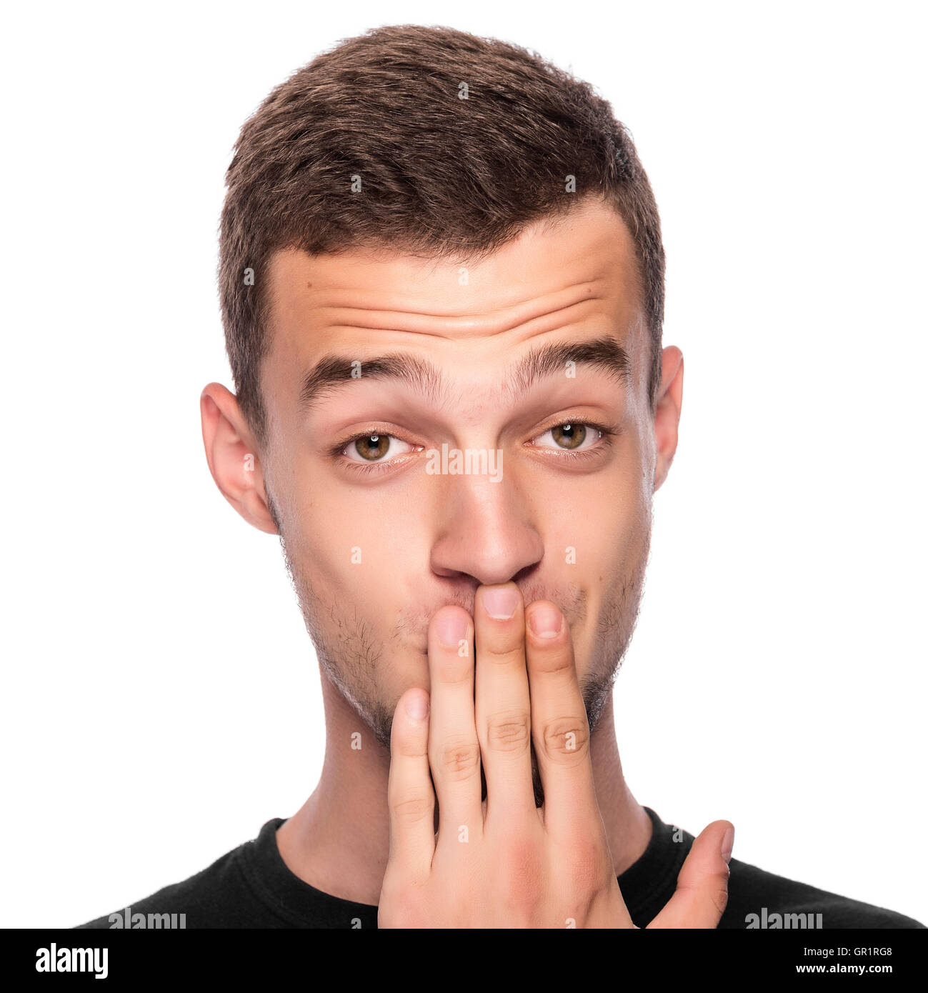 L'uomo con la mano che copre la sua bocca su sfondo bianco. Foto Stock