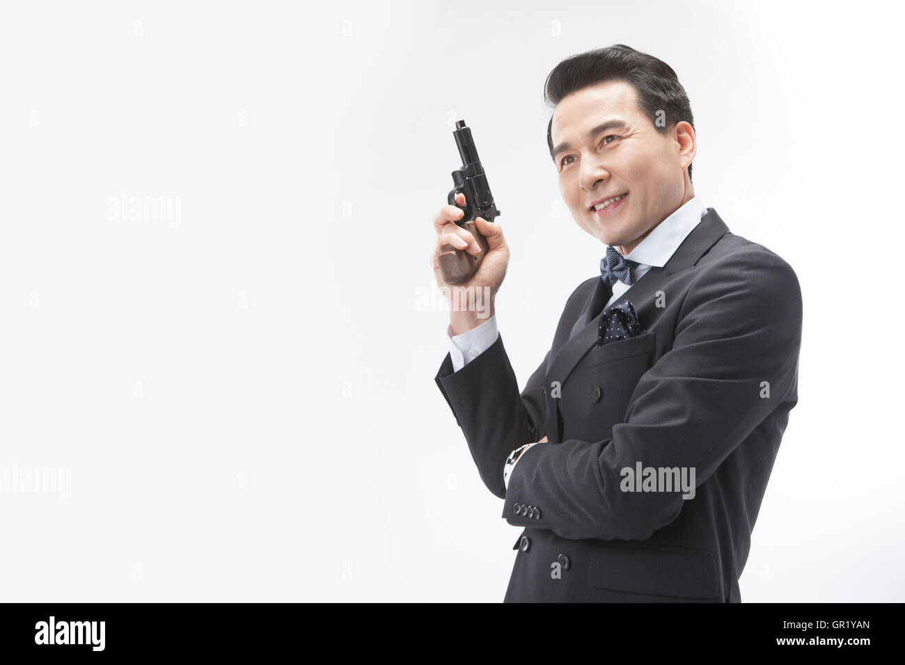 Ritratto di sorridere uomo di mezza età in tuta in possesso di una pistola Foto Stock