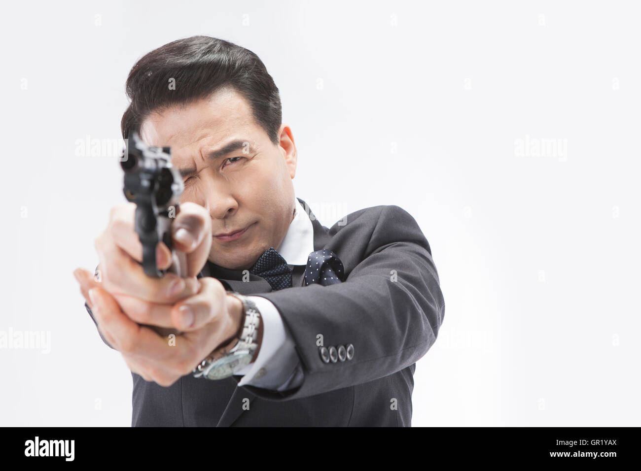 Ritratto di uomo di mezza età in tuta in possesso di una pistola con una strizzatina d'occhio Foto Stock