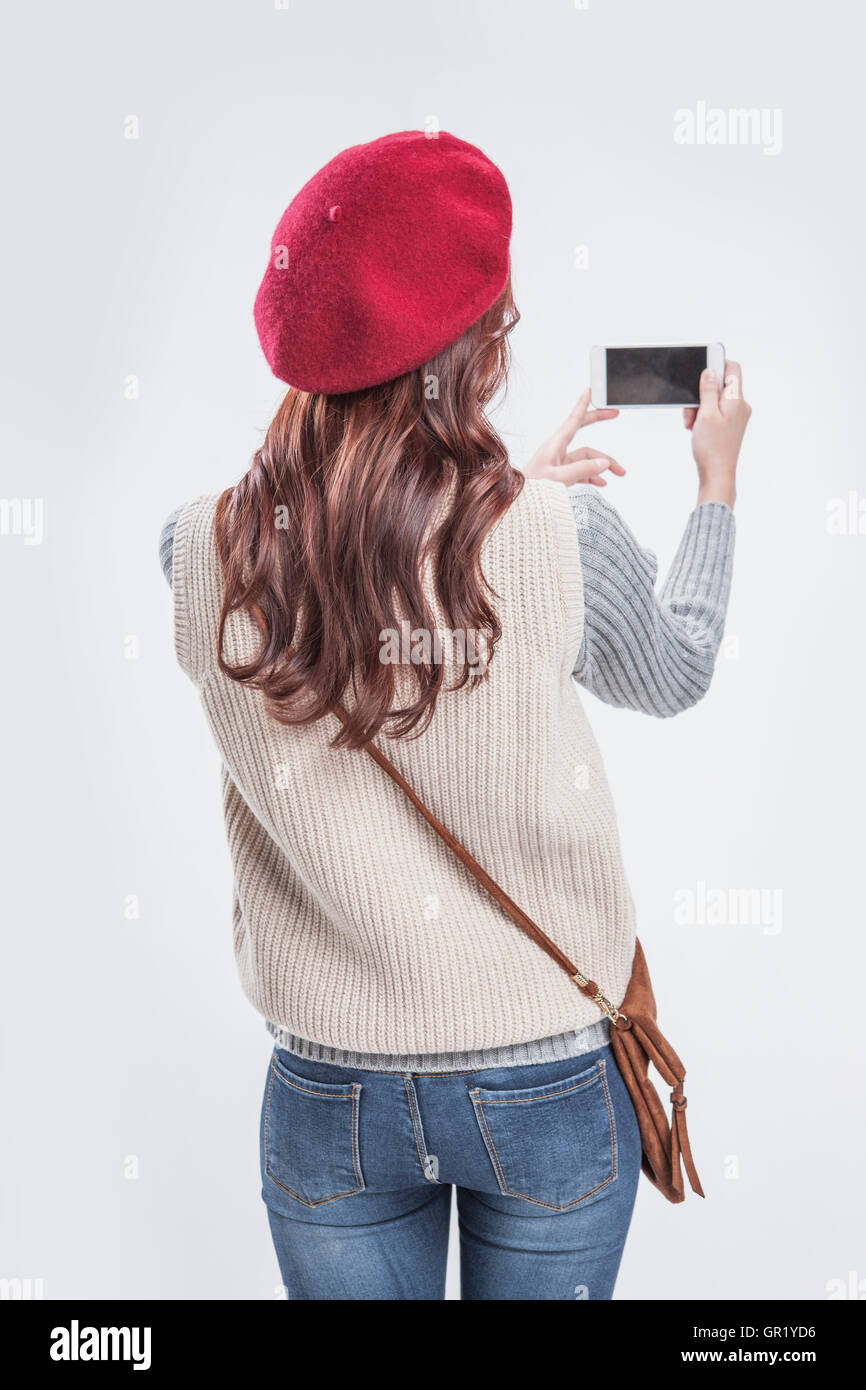 Retro della donna in tenuta casual uno smartphone Foto Stock