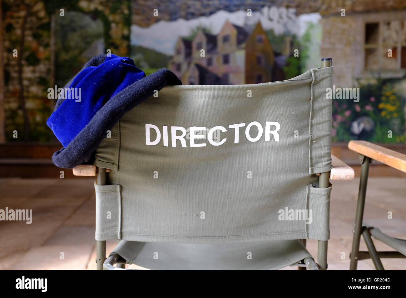 Svuotare del direttore della cattedra di fronte a un dipinto di sfondo dello stadio, con un cappello sullo schienale Foto Stock