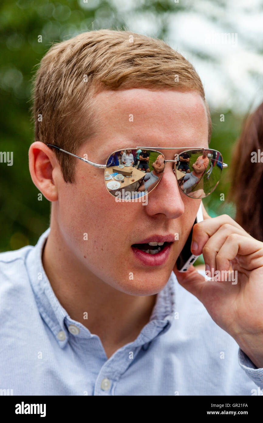 Una buona ricerca giovane uomo utilizzando un telefono cellulare, Sussex, Regno Unito Foto Stock