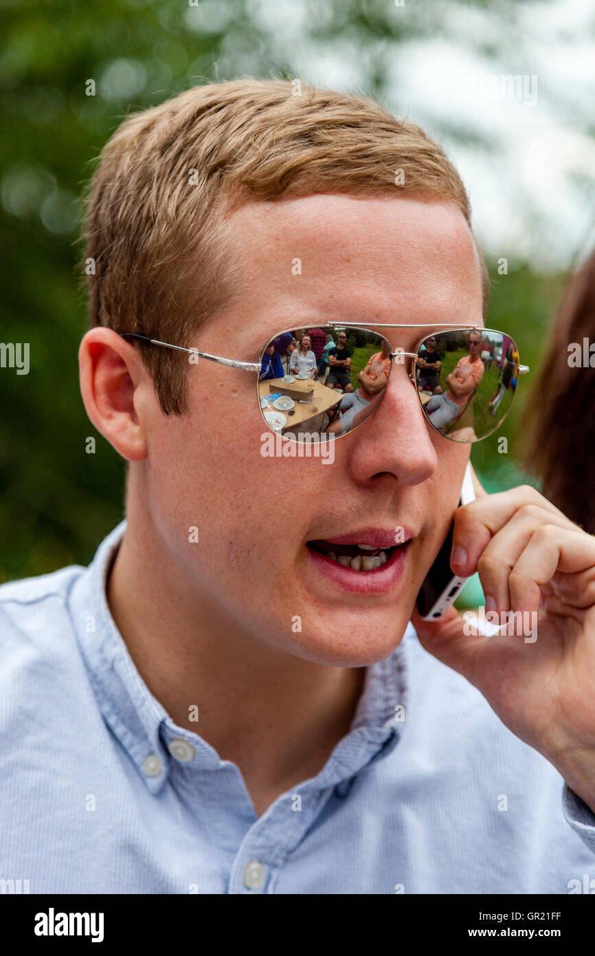 Una buona ricerca giovane uomo utilizzando un telefono cellulare, Sussex, Regno Unito Foto Stock