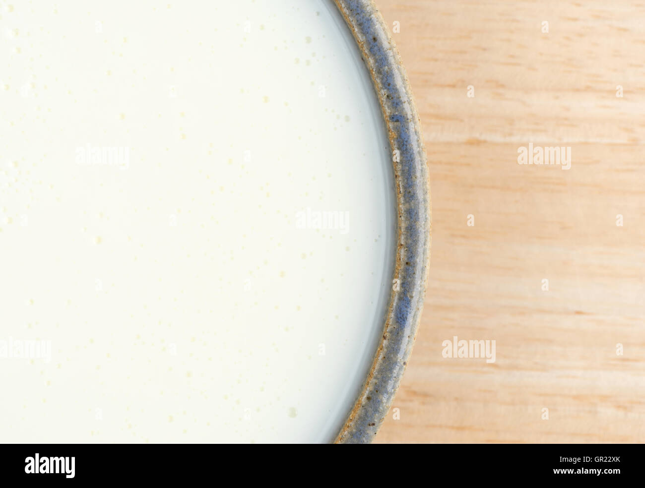 Top vista ravvicinata di una tazza di siero di latte su una tavola di legno. Foto Stock