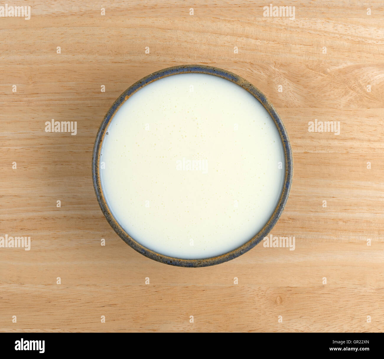 Vista dall'alto di una tazza di siero di latte su una tavola di legno. Foto Stock