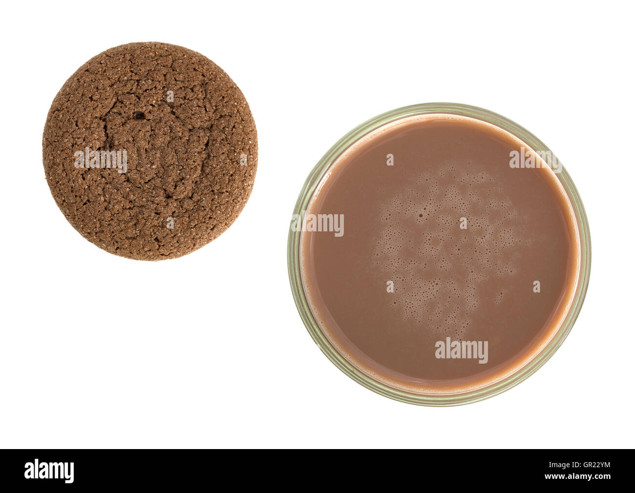 Vista dall'alto di un bicchiere di cioccolato al latte con un cookie al lato su uno sfondo bianco. Foto Stock