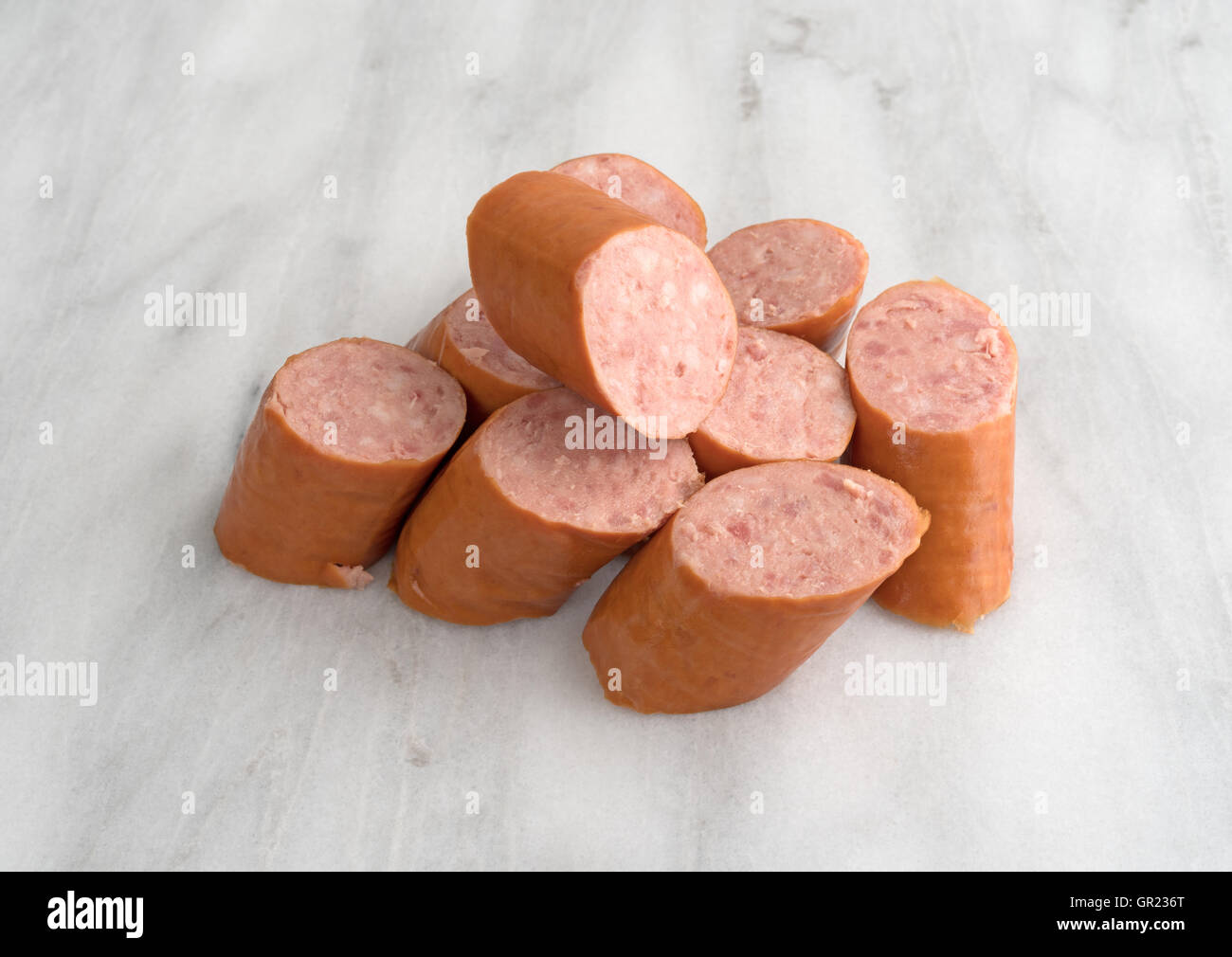 Più fette di Polska Kielbasa su un marmo grigio tagliere. Foto Stock