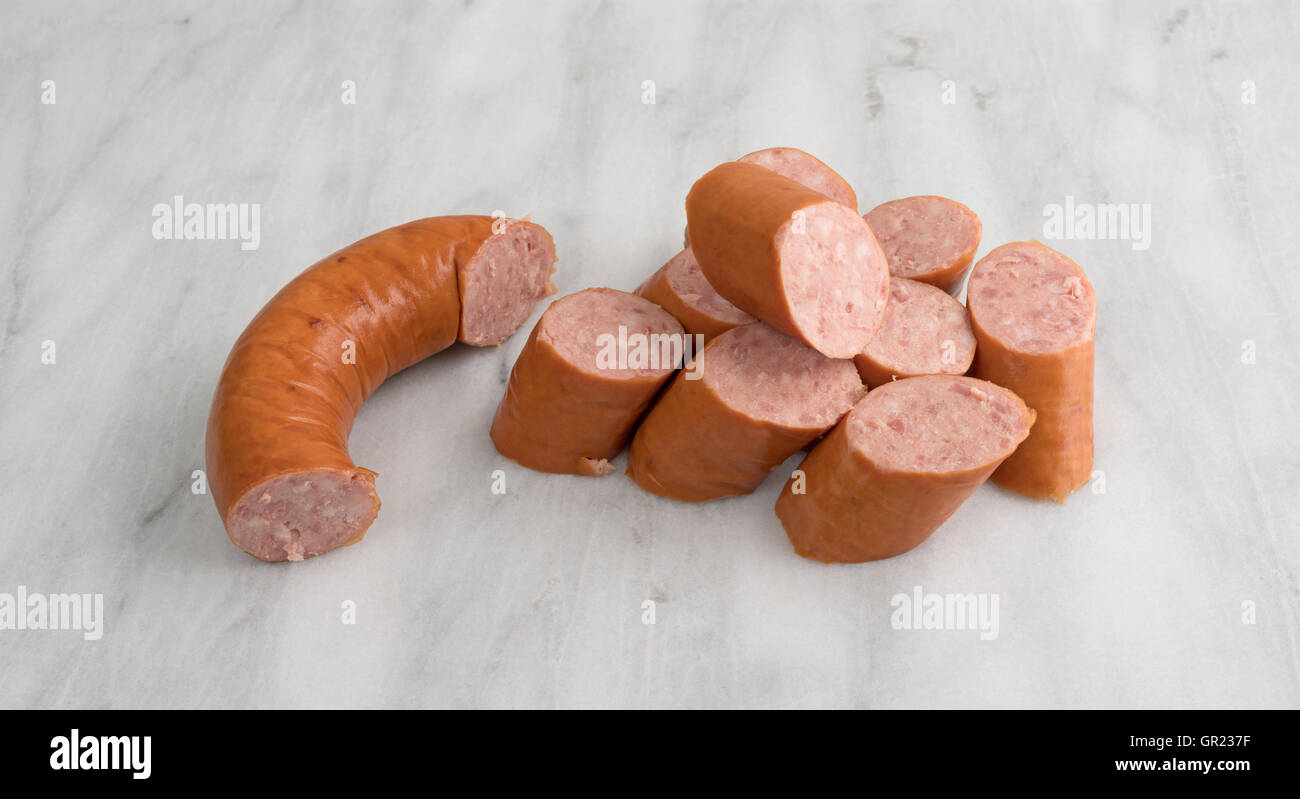 Più fette di Polska Kielbasa su un marmo grigio tagliere. Foto Stock