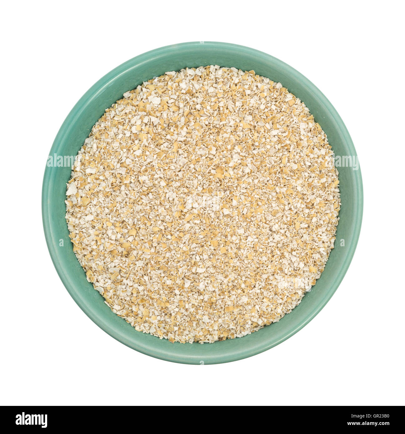 Vista in pianta secca di crusca di avena cereale a caldo in un recipiente verde isolato su uno sfondo bianco. Foto Stock
