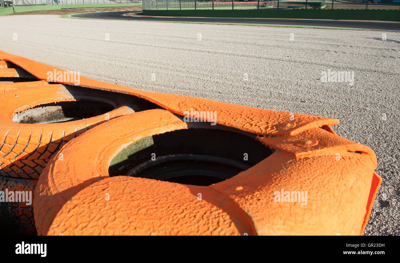 Arancione barriera di pneumatici close up fuori pista su motor sport circuito con ghiaia spazio di sicurezza Foto Stock