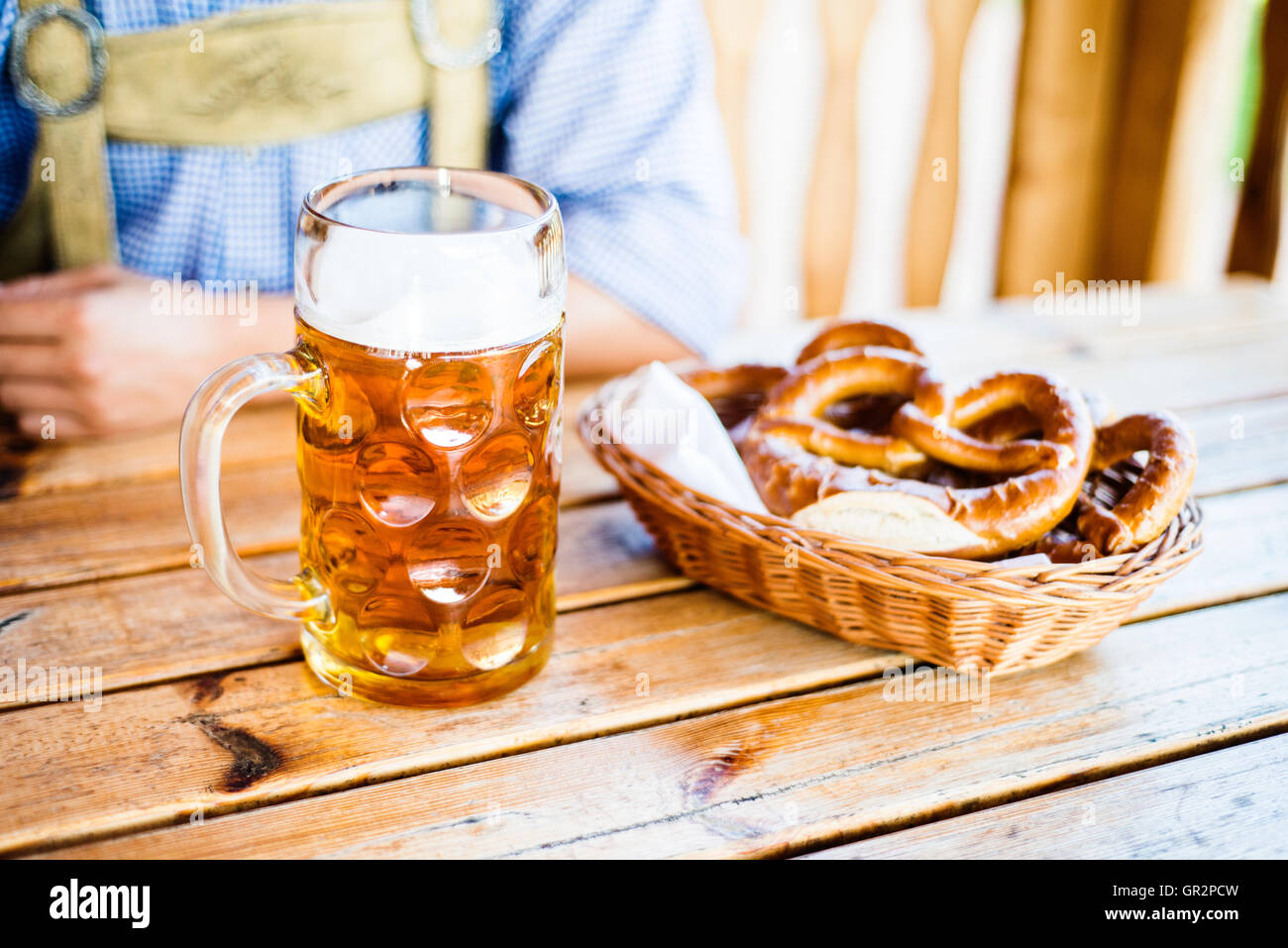 Uomo in tradizionali abiti bavarese con birra e salatini Foto Stock