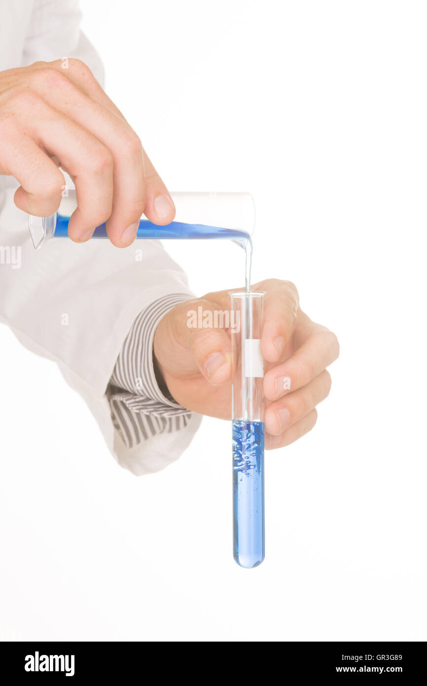 Le mani di uno scienziato in un camice blu versatore chemical in provette. Foto Stock