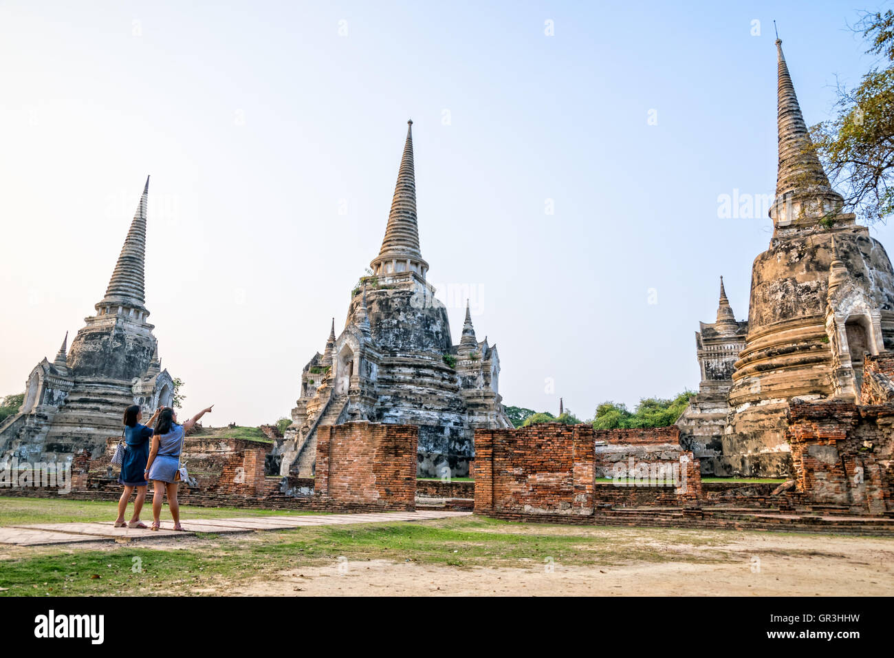 I turisti madre e figlia fotografia antiche rovine e la pagoda di Wat Phra Si Sanphet Tempio famose attrazioni di Ayutthaya Foto Stock