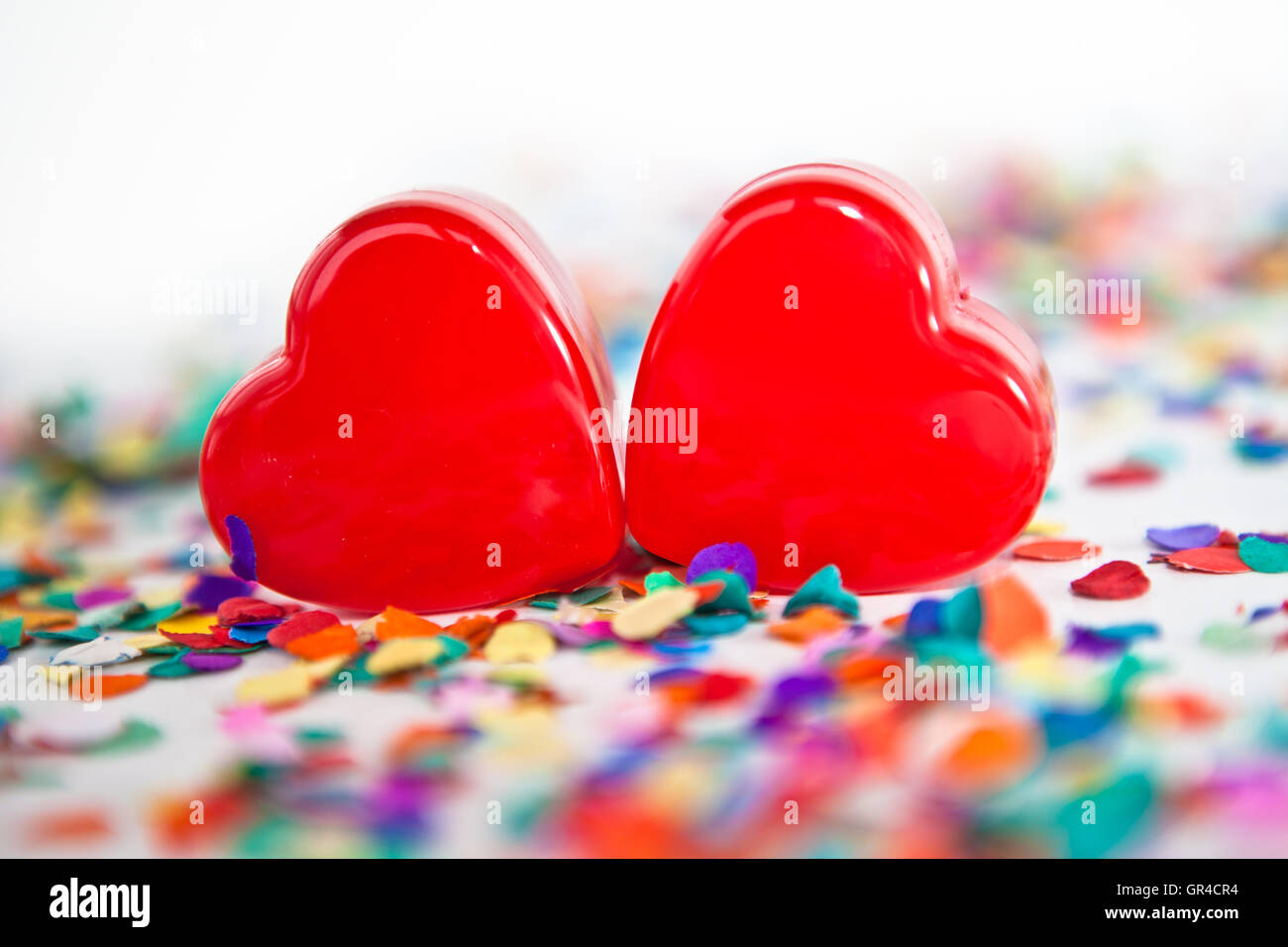 Due cuori rossi con i confetti Foto Stock