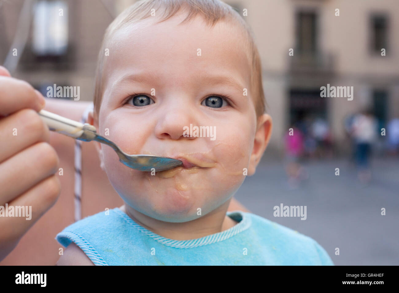 Madre che nutre il suo bambino Ragazzo con frutta poltiglia all'aperto Foto Stock